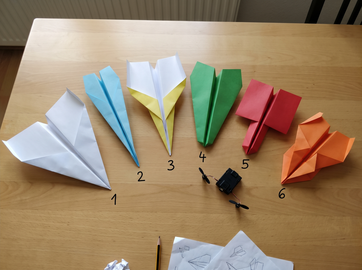 Six modèles d'avions en papier numérotés sur les ailes
